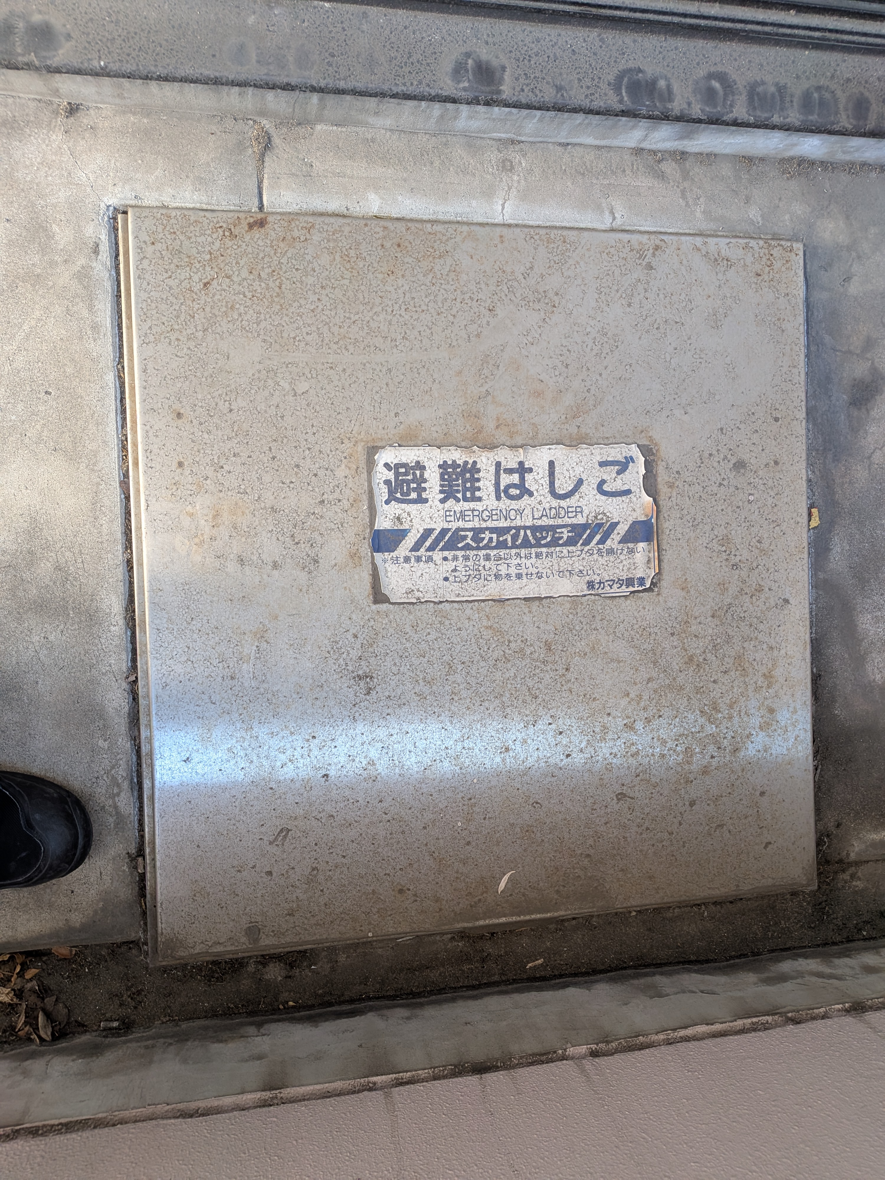 横須賀市の共同住宅で交換前の避難ハッチ（錆が進んだ上蓋）