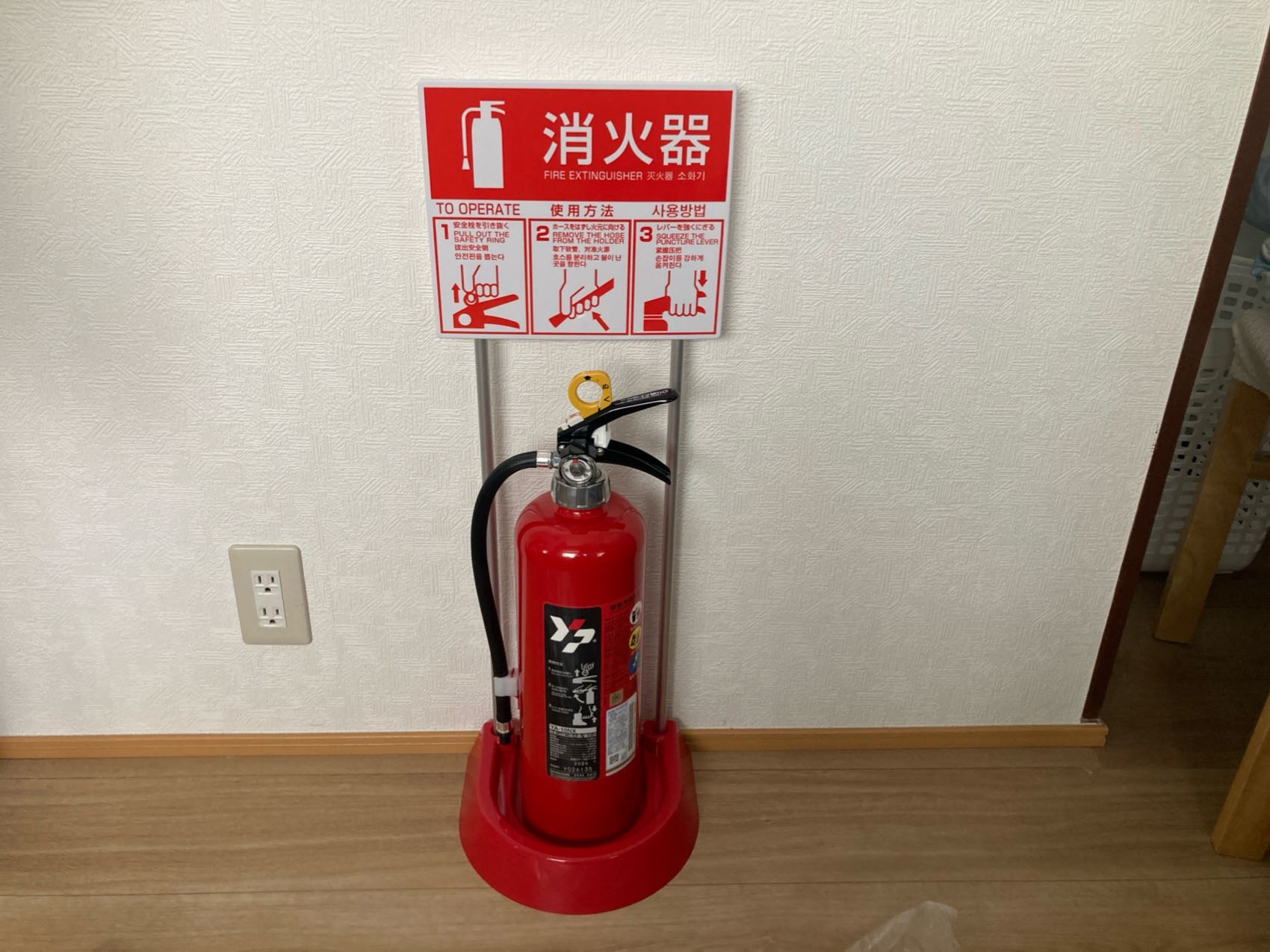 民泊に新設した消火器。3か国語表記の使用方法標識と設置台をあわせて設置(東京都新宿区)