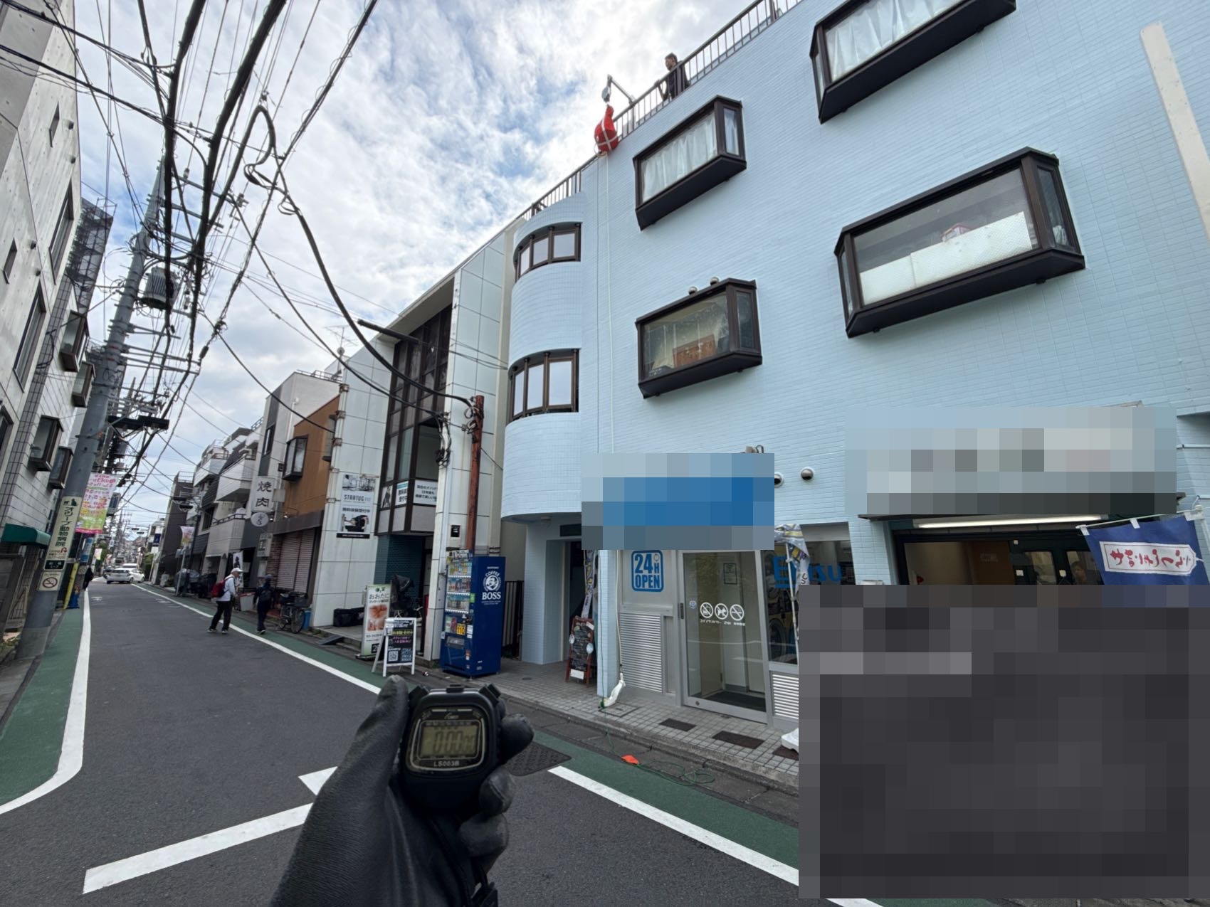 地上からストップウォッチで緩降機の降下速度を測定する降下試験の様子