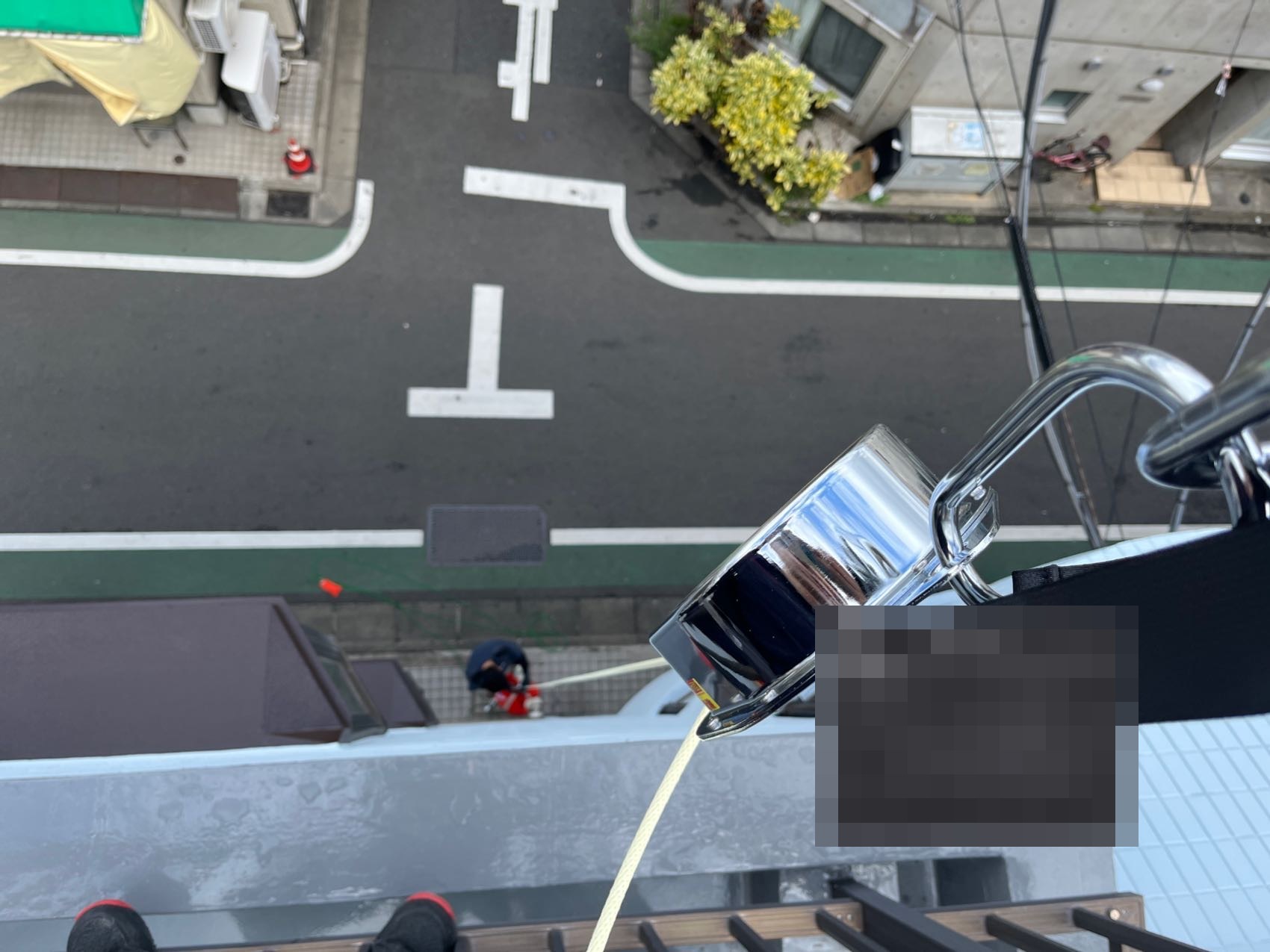 緩降機の降下試験。屋上から降下試験機を使ってロープを降下させる