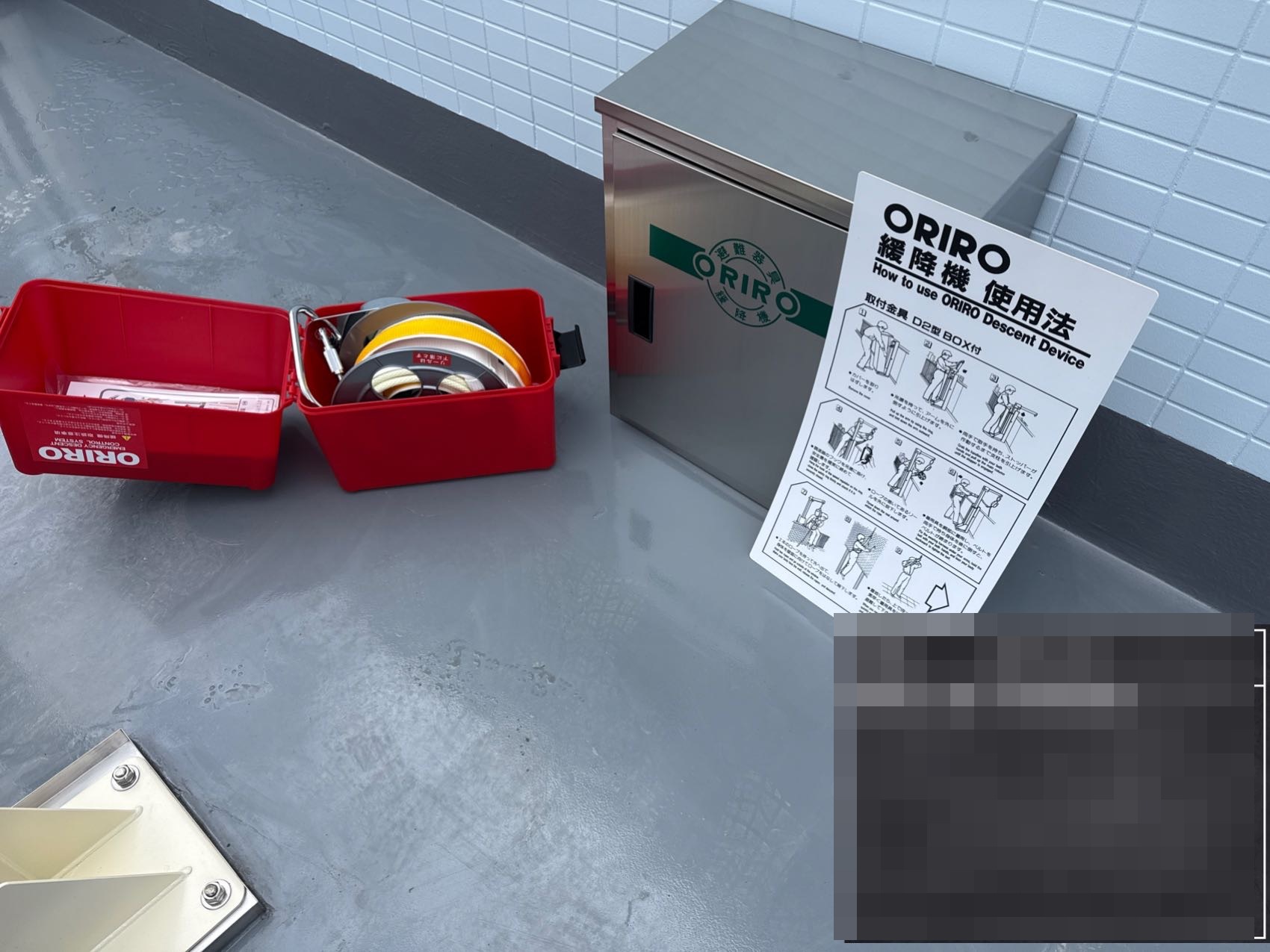 緩降機本体とステンレス製格納箱、使用説明板の設置後