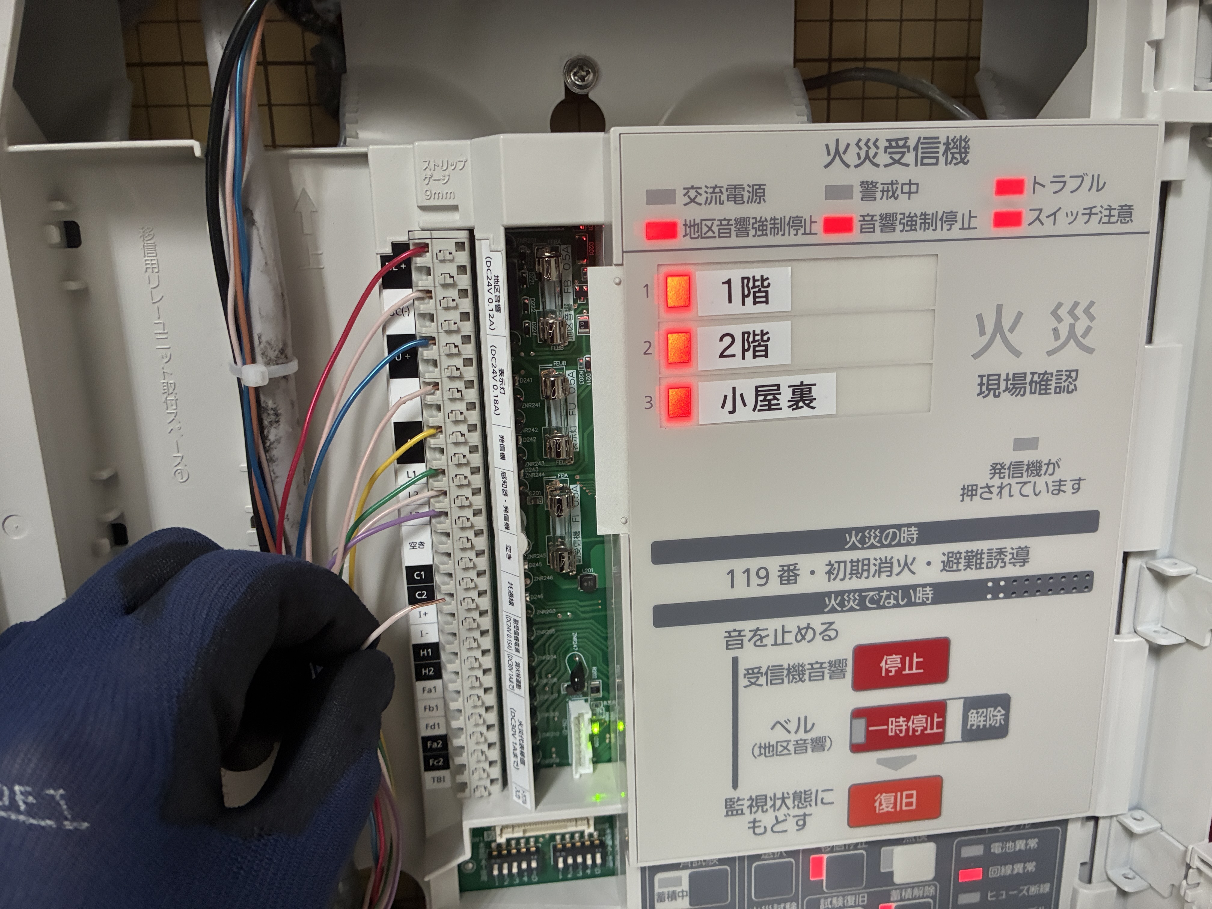 交換後のパナソニック製P型2級受信機の内部。端子台に感知器回線・発信機・地区音響・表示灯の配線を接続し、1階・2階・小屋裏の火災表示試験中