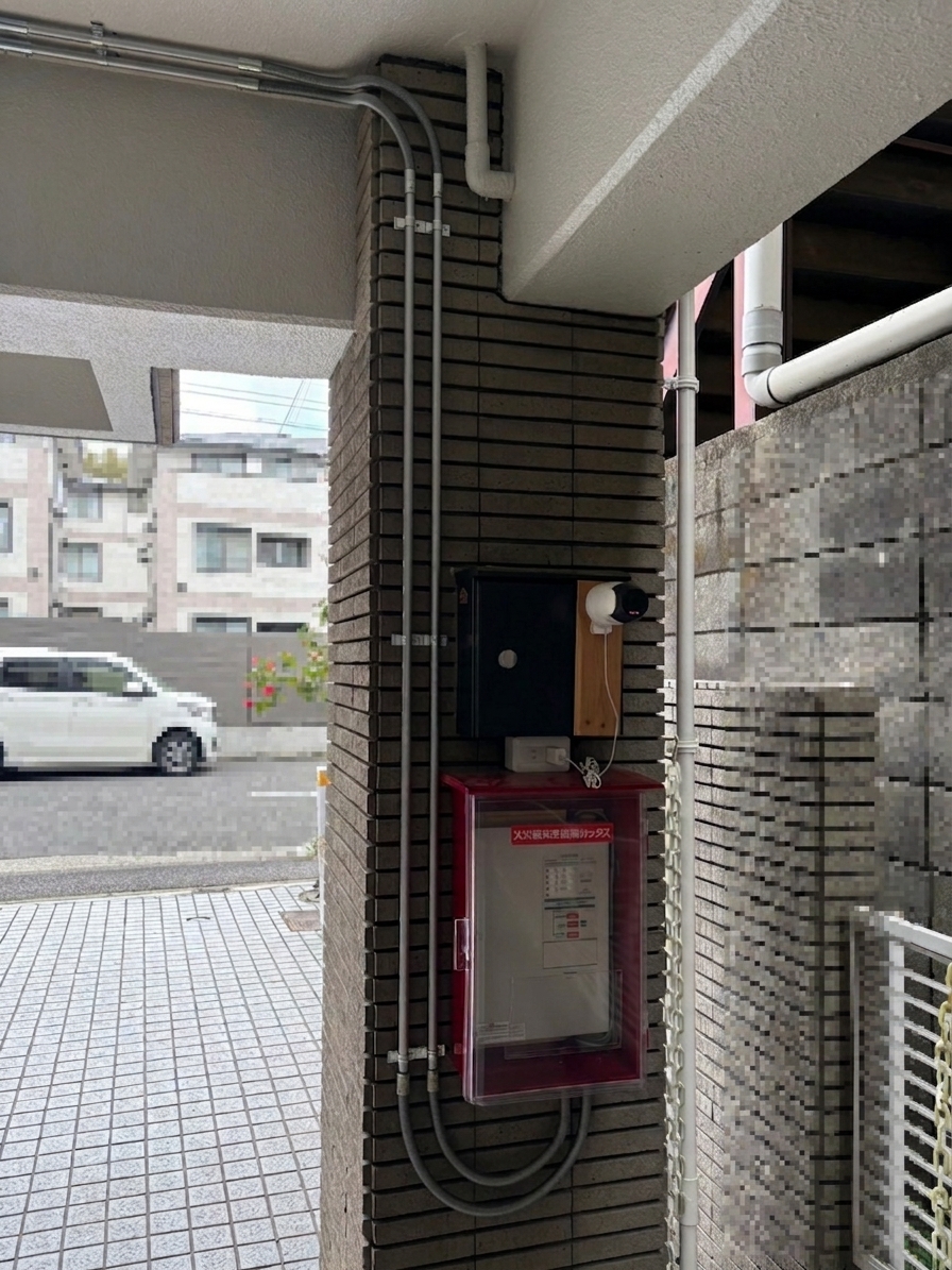 柱の裏側に設置した赤い樹脂製の受信機格納箱。消防署の要望により目立つ赤色を採用。配線は金属管で保護