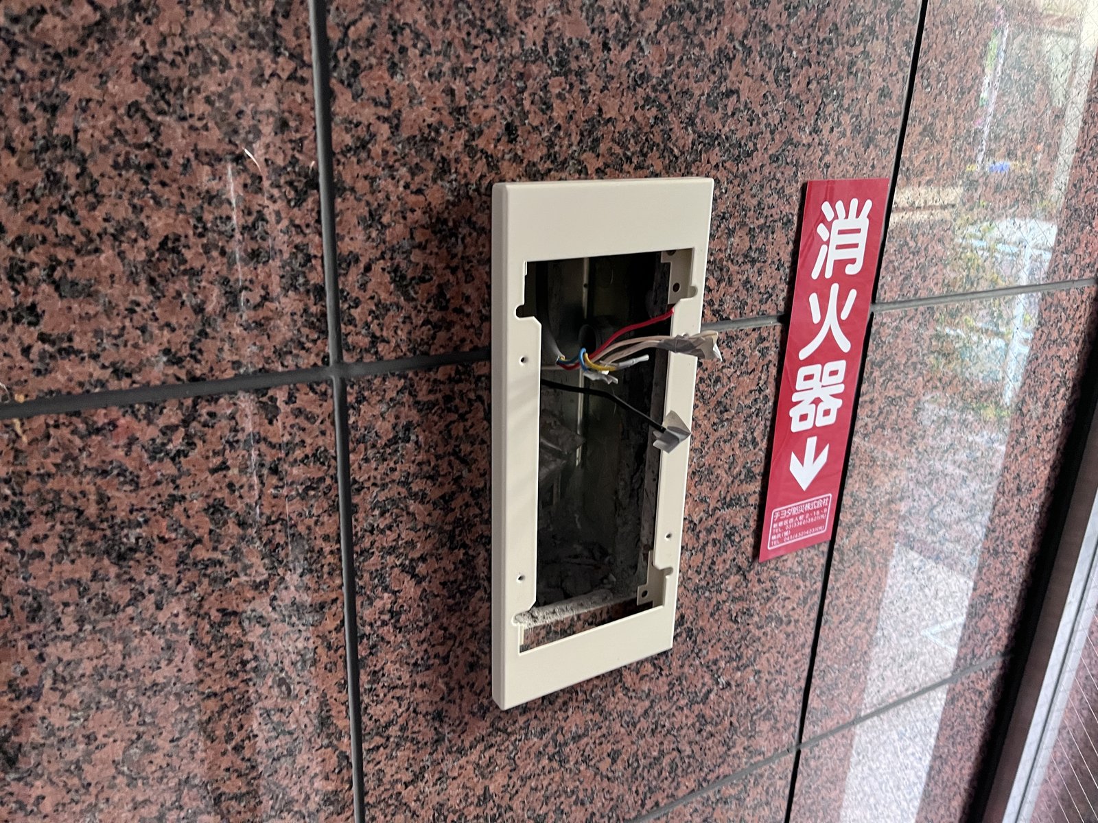 旧非常警報複合装置を撤去した後の壁面埋込ボックス。内部の配線が見えている状態