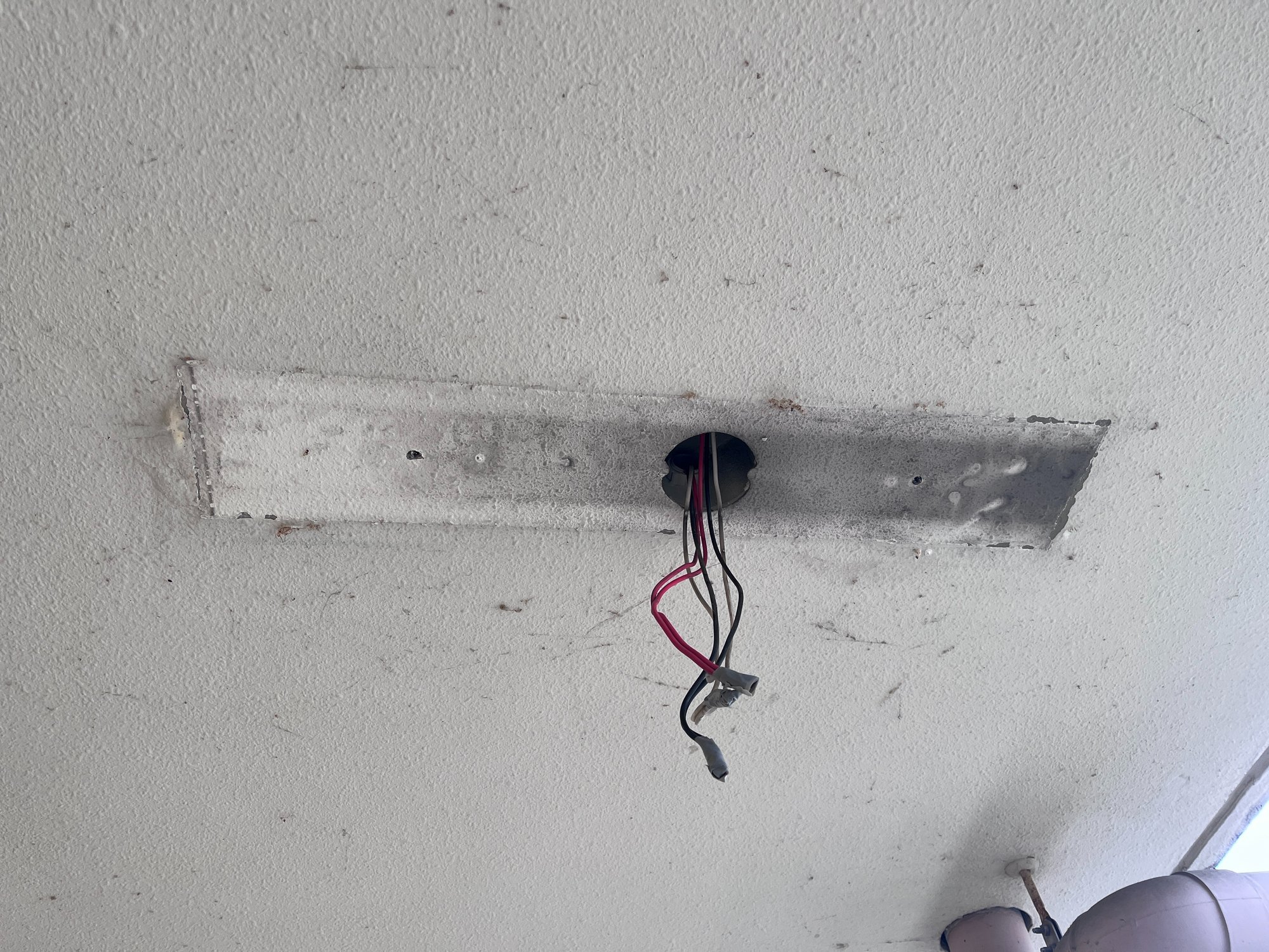 旧非常灯を撤去した直後の天井。器具の跡が残り、電源配線が露出している状態
