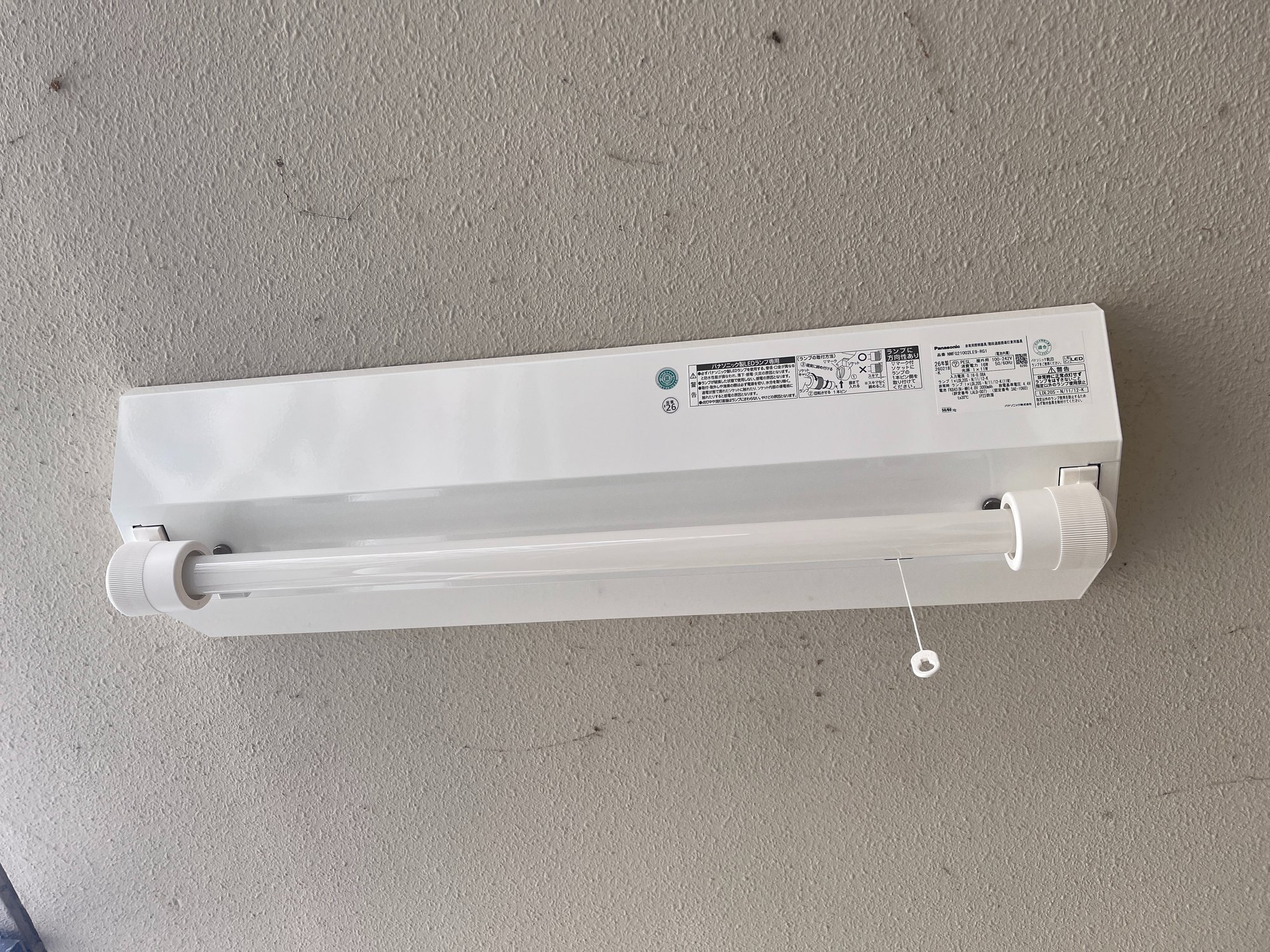 取り付けた新しいLED非常灯の銘板。パナソニック NWFG21002LE9-RG1 防滴タイプ、蓄電池内蔵