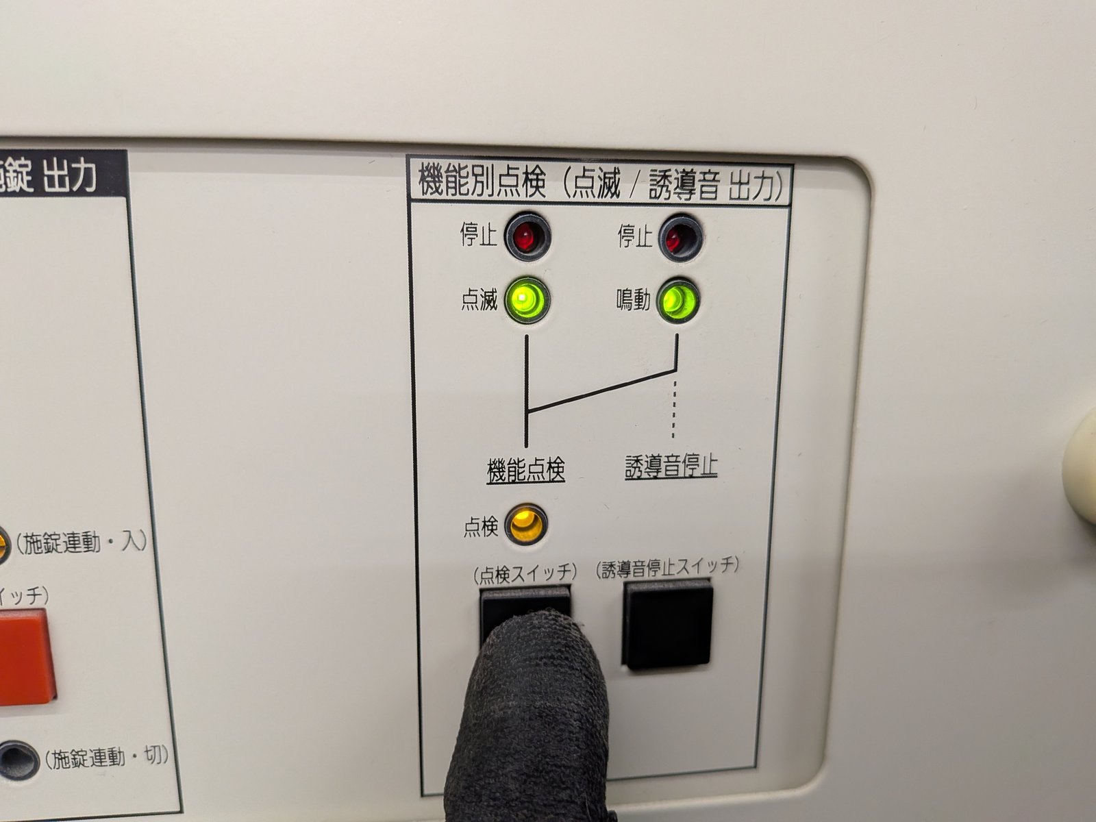 誘導灯信号装置の点検スイッチから点滅・音声誘導の起動信号を送る試験の様子