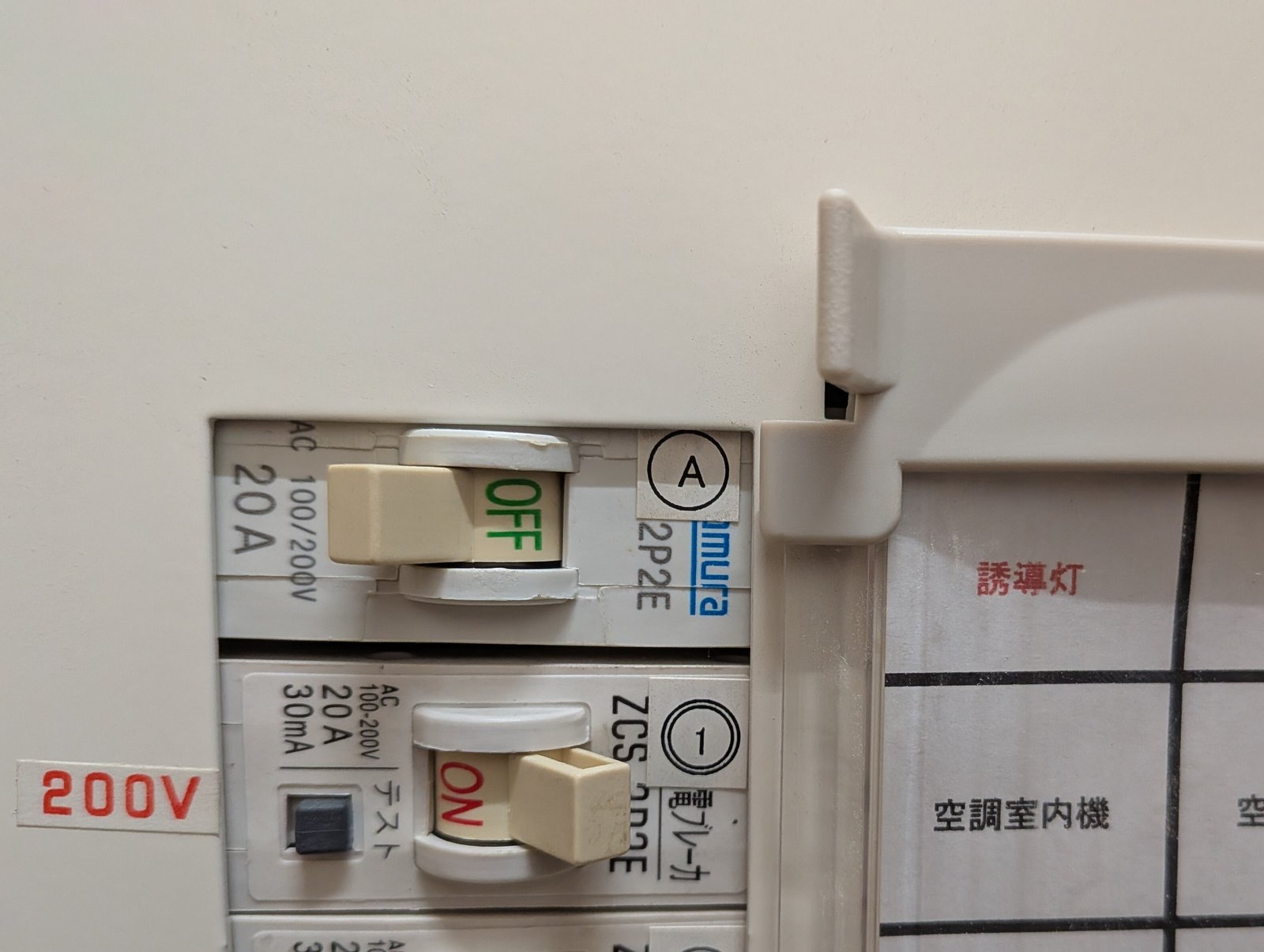 分電盤で誘導灯の電源が専用回路になっていることを確認している様子