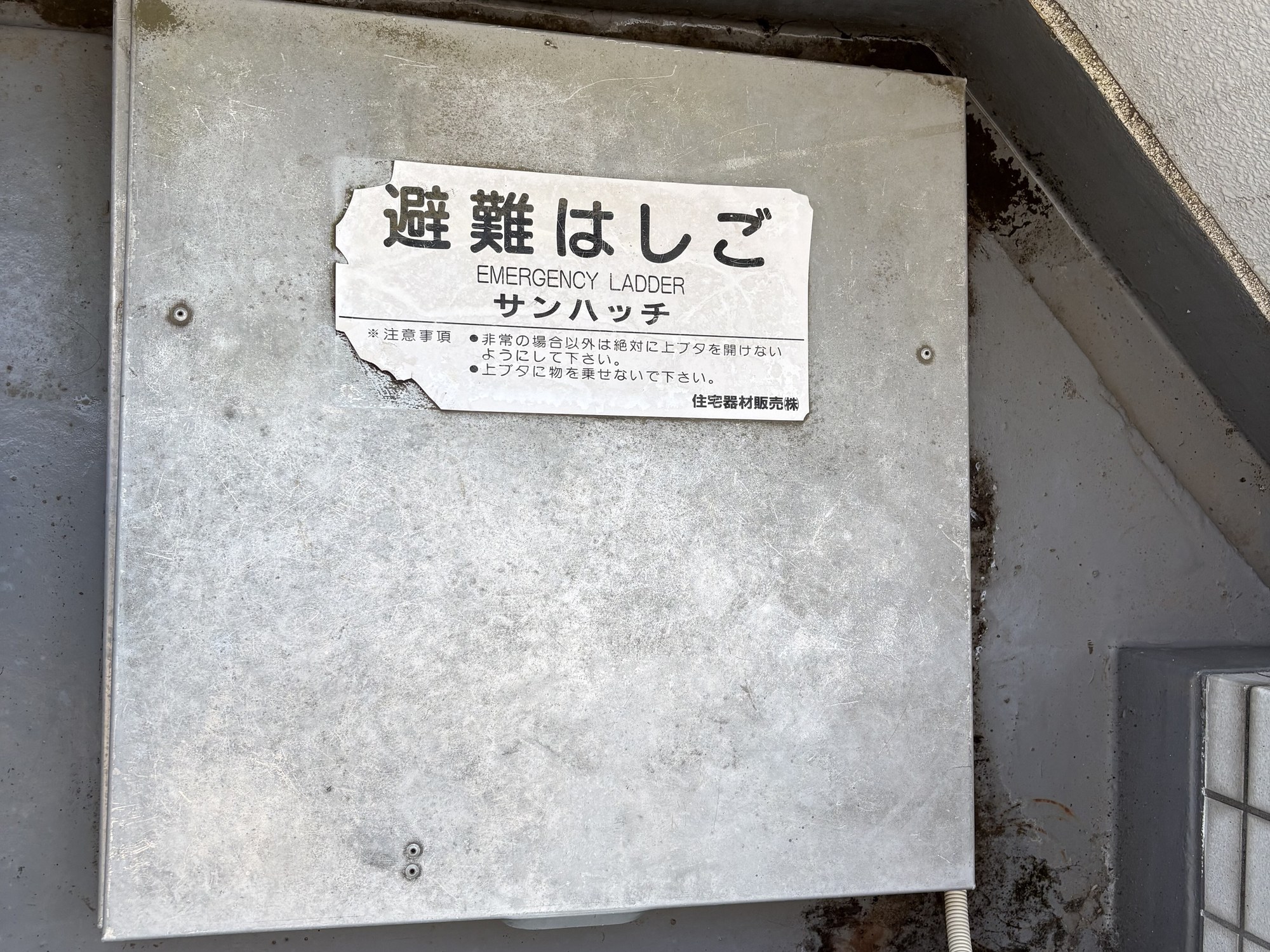 交換前の避難ハッチの上蓋。スチール製で表面に汚れや腐食が見られる