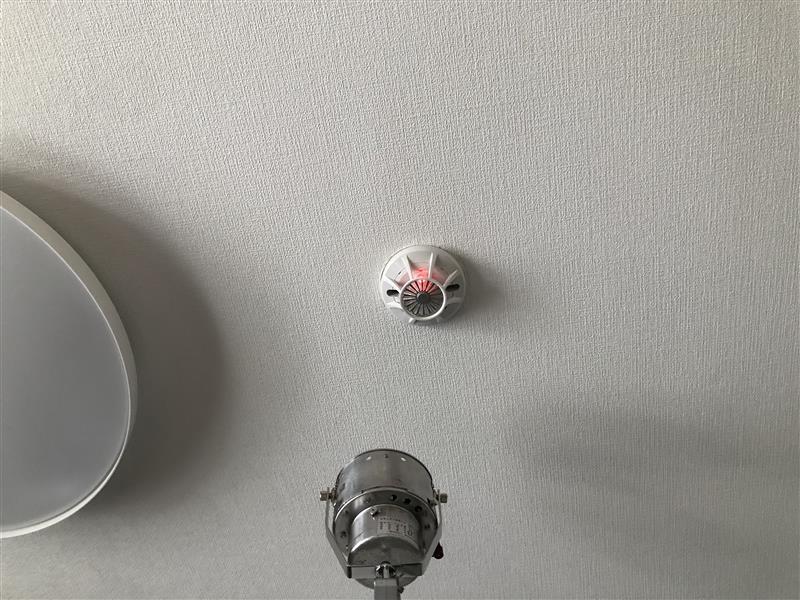 交換後の差動式スポット型感知器の加熱試験。作動して確認灯が赤く点灯している