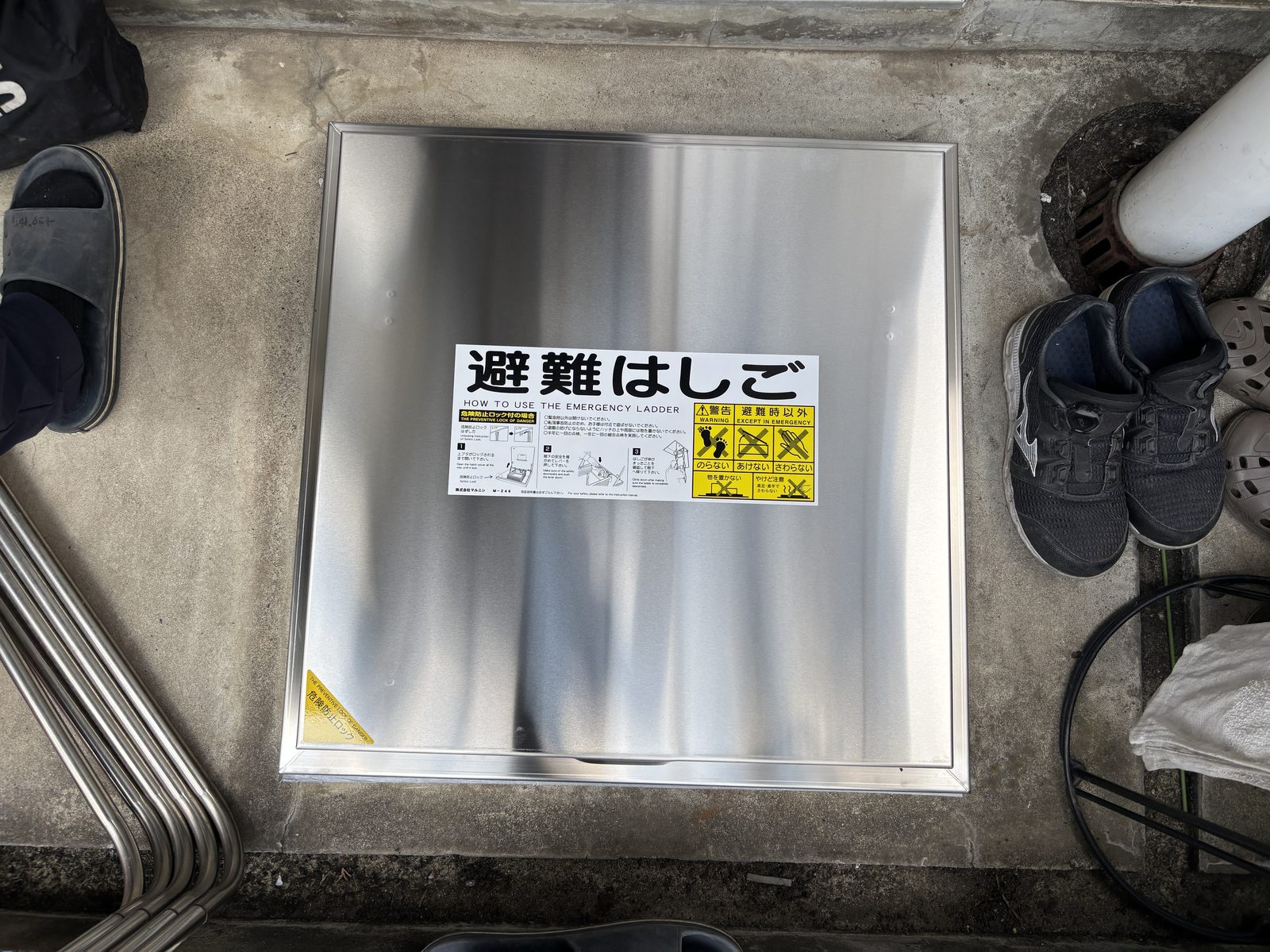 交換後のステンレス製避難ハッチ。上蓋に使用方法のステッカーが貼られている