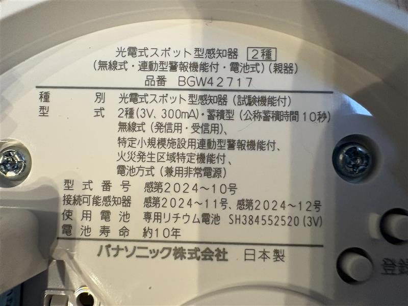 特定小規模施設用自動火災報知設備の親機の銘板。火災発生区域特定機能付・電池寿命約10年の表示