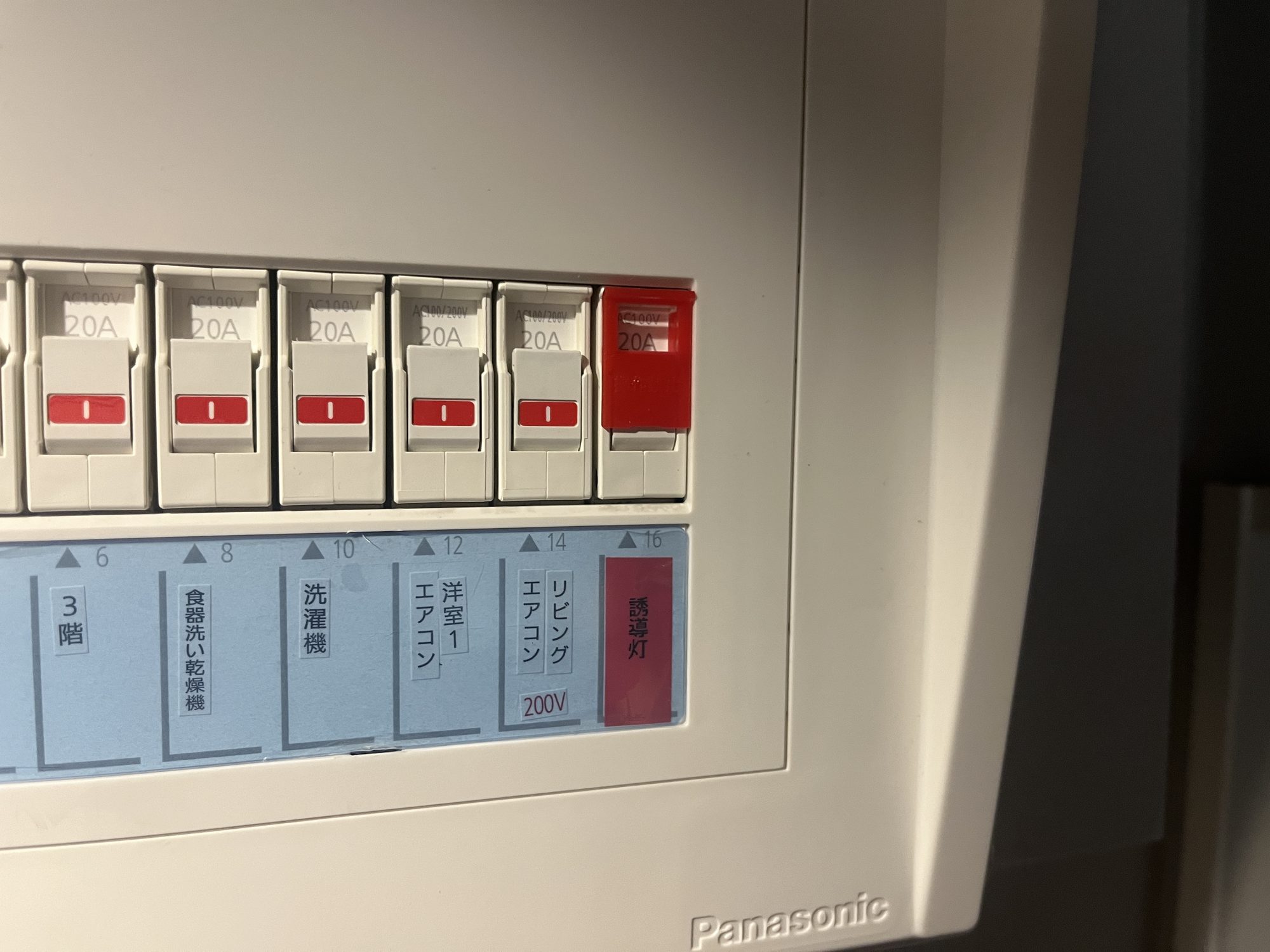 住宅用分電盤の右端に増設した誘導灯専用ブレーカー（赤色カバー・誘導灯の表示）