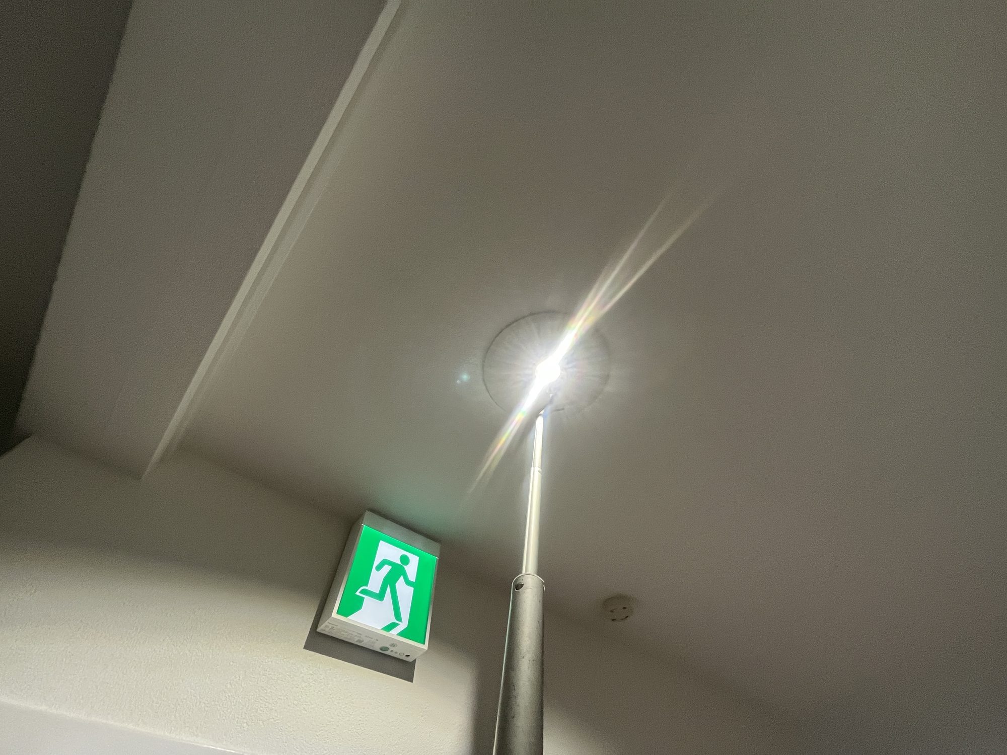 天井に設置したLED非常灯の点灯試験。停電時に避難経路を照らす