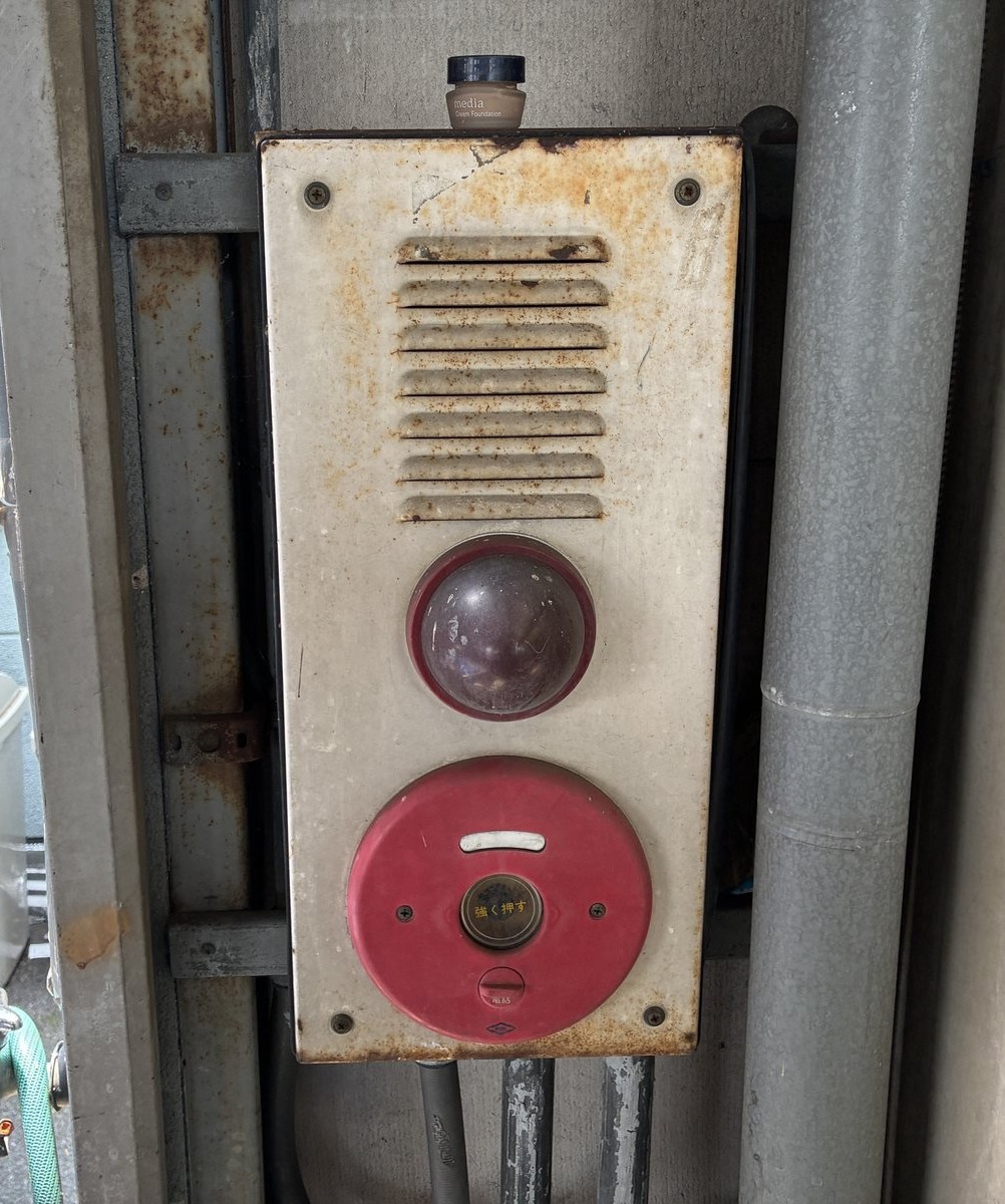 交換前の屋外設置の発信機総合盤。長年の風雨で盤面全体に錆が広がっている