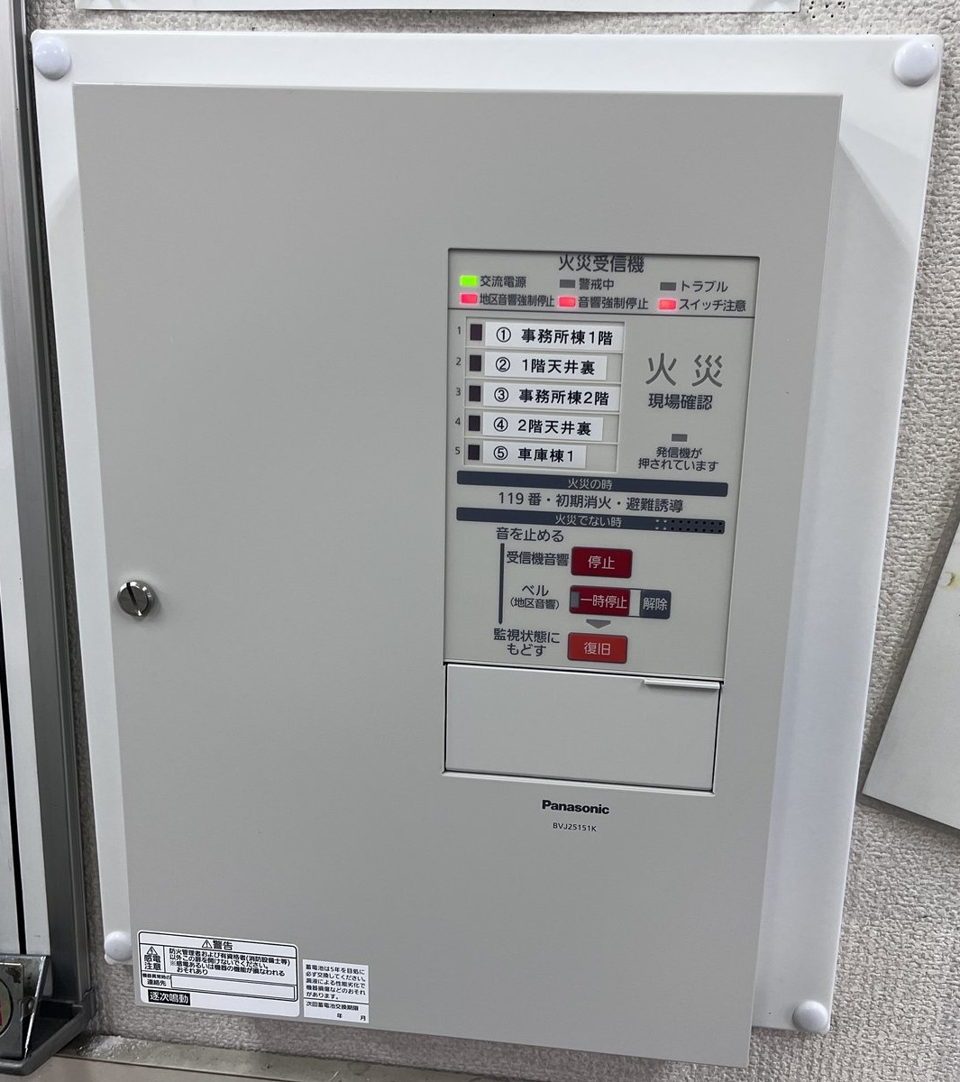 交換完了後の新しい火災受信機。扉を閉めた状態で交流電源灯が点灯し、正常に監視している