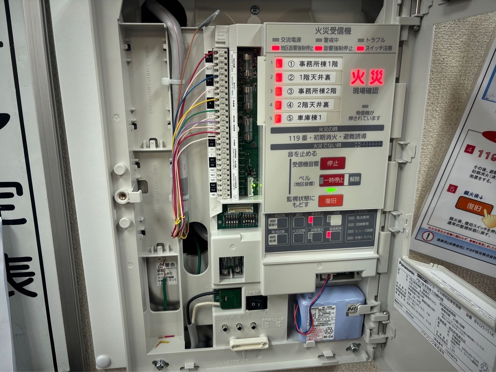 新しいパナソニック製P型2級火災受信機の内部。回線ごとに結線し、火災試験で地区表示窓と火災灯の点灯を確認している ※施工中の動作試験