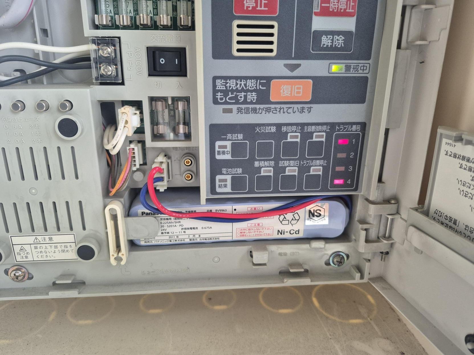 受信機内部。トラブル番号の表示が点灯し、2011年製の予備電源バッテリーが見える