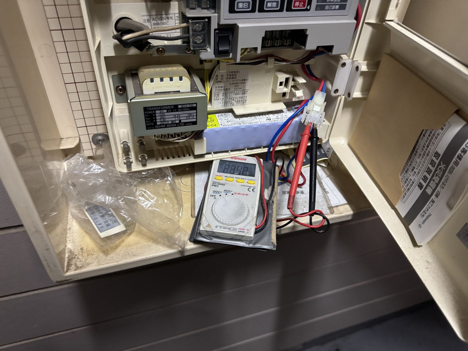 受信機の予備電源バッテリーの電圧をテスターで測定している様子