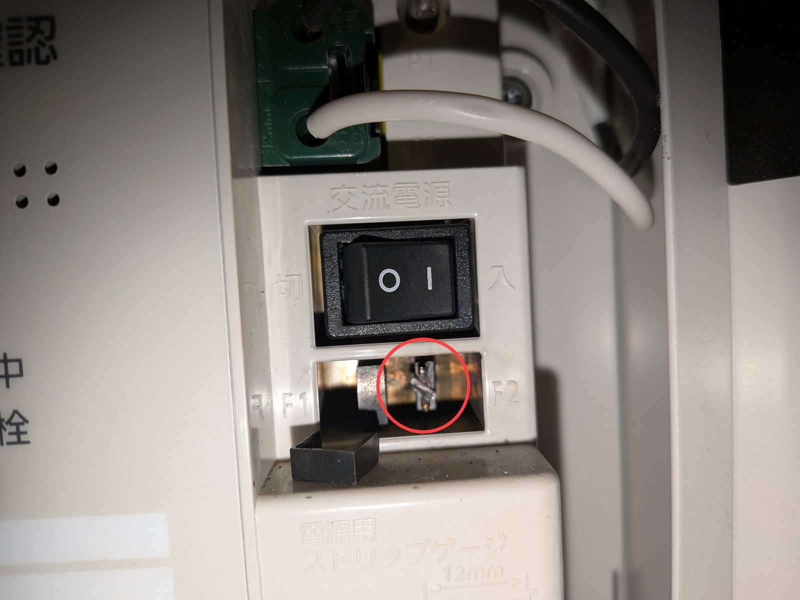 受信機の電源部で焼損したヒューズを赤丸で示した写真