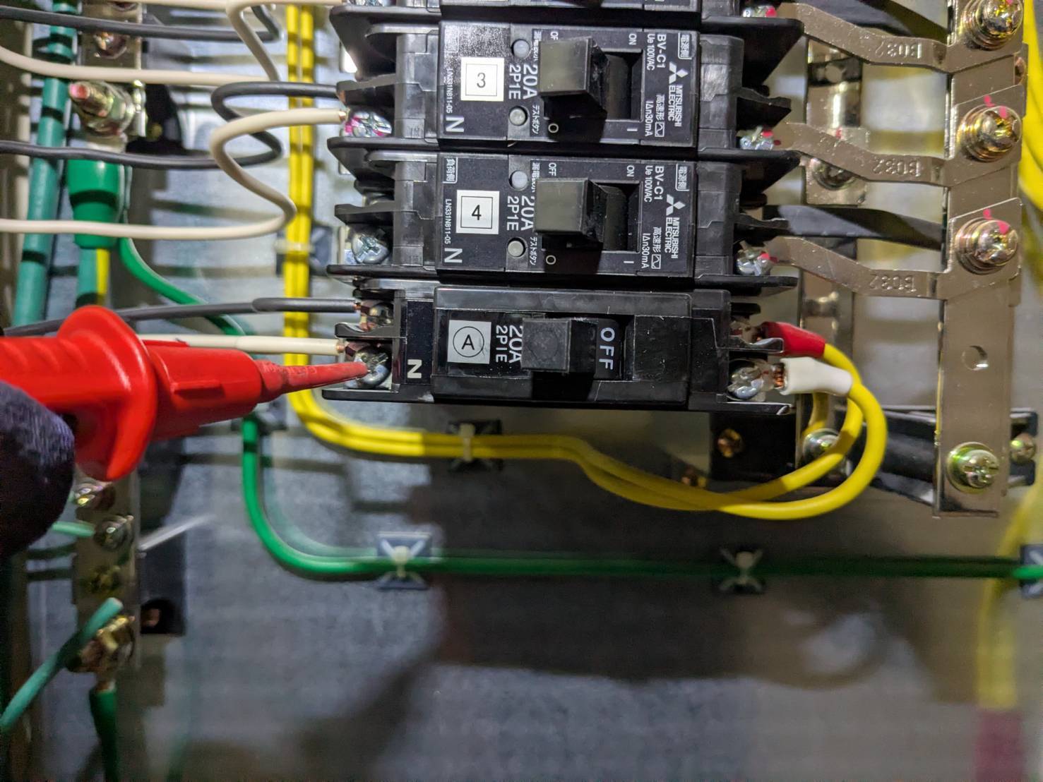 テナントの分電盤で誘導灯回路の絶縁抵抗を測定している様子