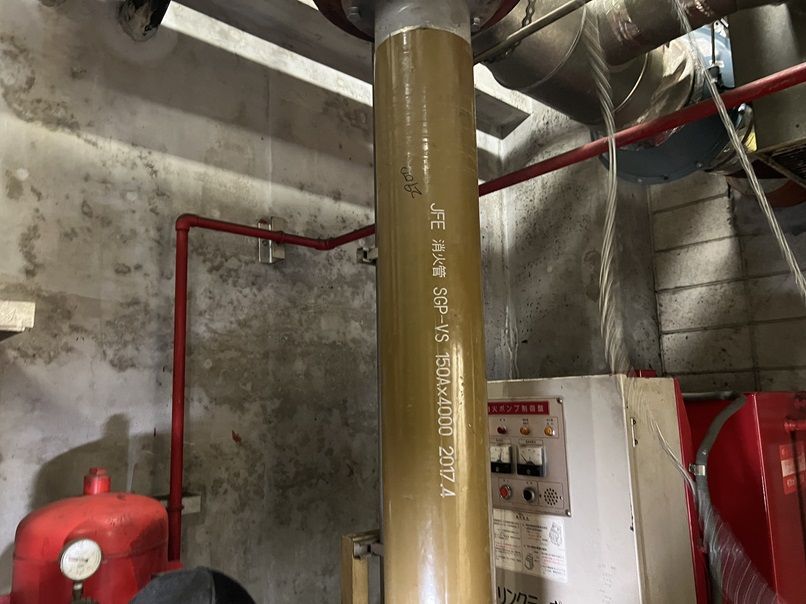 ポンプ室に立てた新しい吸水管。配管の表面にJFE 消火管 SGP-VS 150A&times;4000の印字がある