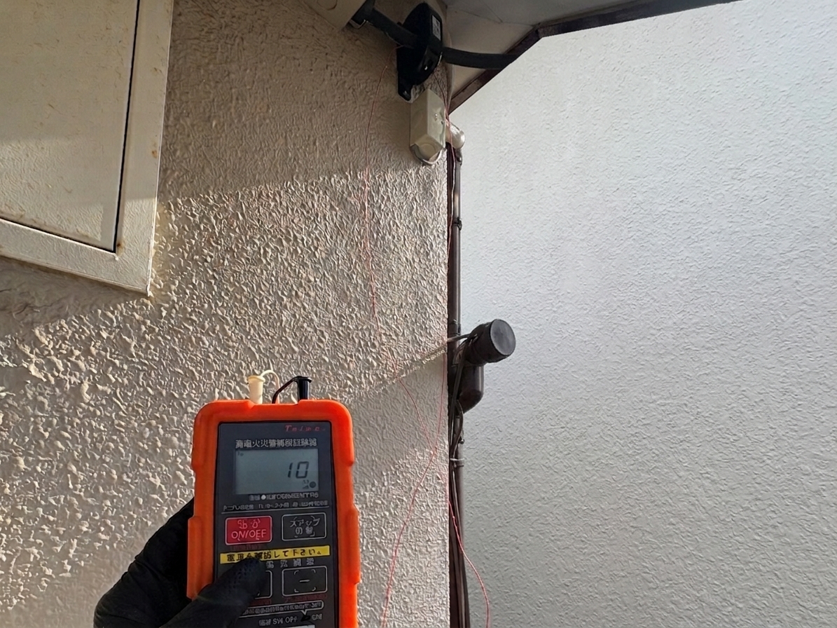 試験中の新しい受信機。漏電の赤ランプが点灯し、作業員が公称作動電流値のダイヤルを確認している