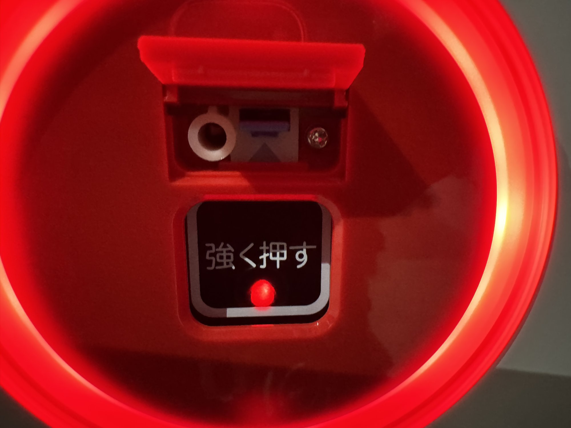 手順1：発信機の赤いプレートを上に持ち上げ、下にある復旧用の部品が見えた状態