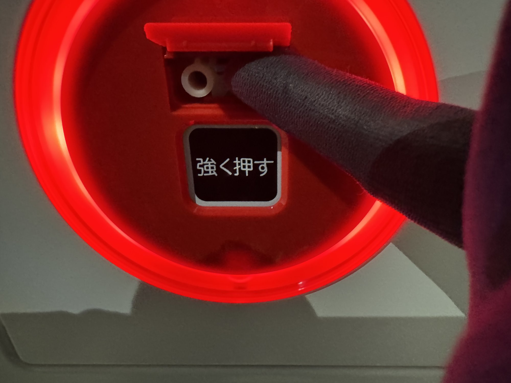 手順2：プレートの下の白い復旧つまみを指で押しているところ