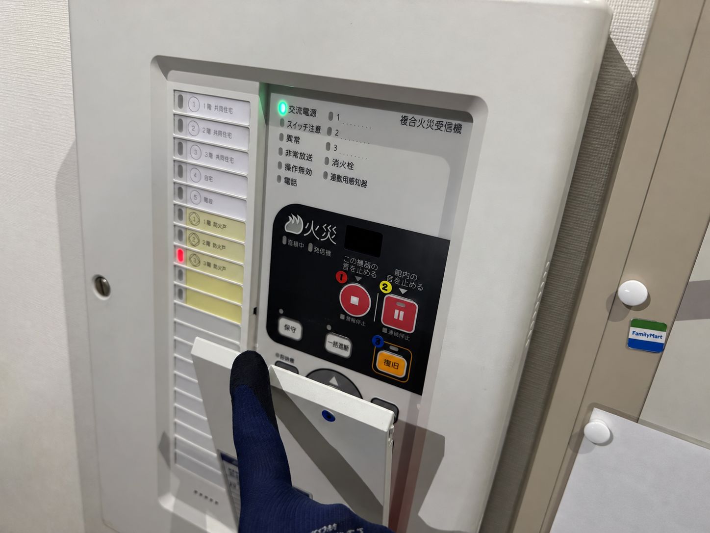 受信機の下側のカバーを手で持ち上げて操作パネルを出しているところ